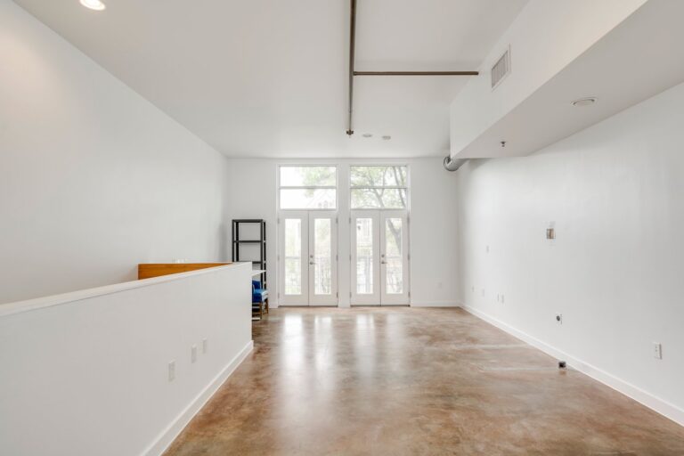 Upper-level workspace with tall windows at 1601 E Cesar Chavez St, Unit 104, Austin, TX 78702